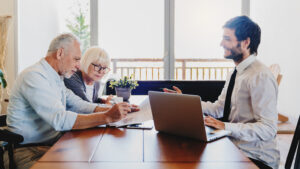 Senior couple going over their retirement policies with financial advisor